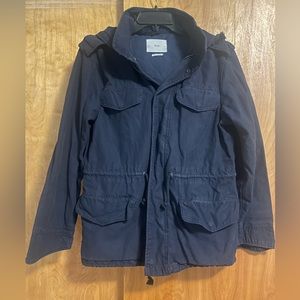 Tna. Canvas work jacket. Zip/ button front. Detachable hood. Asymmetrical cuffs.